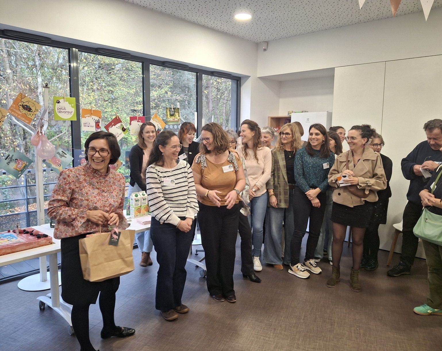 Les personnes du comité devant le gâteau d'anniversaire